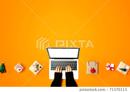 Person using a laptop computer with Christmas gift boxes Person using a laptop computer with Christmas gift boxes 71370113