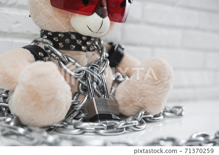 toy bear dressed in leather straps harness accessory for BDSM chained with a lock 71370259
