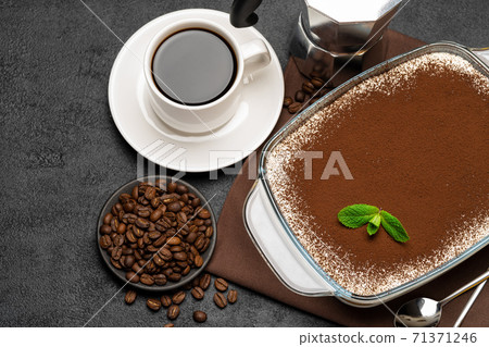 Traditional Italian Tiramisu dessert in glass baking dish, cup of fresh hot espresso and coffee maker on concrete background 71371246