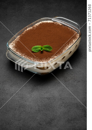 Traditional Italian Tiramisu dessert in glass baking dish on concrete background 71371268