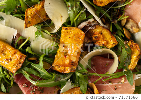 Salad with arugula, pumpkin, prosciutto and parmesan 71371560