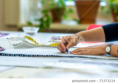 preparation of a template for making a dress in a tailors shop preparation of a template for making a dress in a tailors shop 71373214