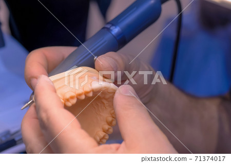 Dental technician working with dental prosthetics - close up view 71374017