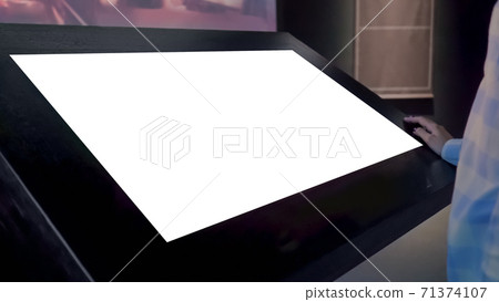 Woman looking at blank white display kiosk at exhibition - white screen concept Woman looking at blank white display kiosk at exhibition - white screen concept 71374107
