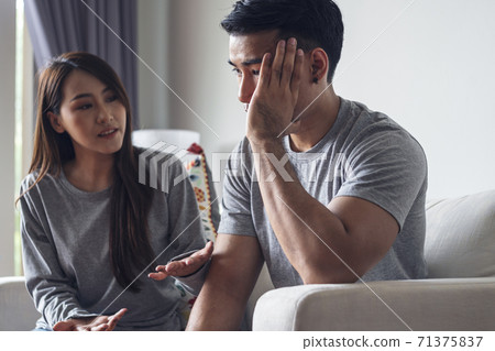 Unhappy young man have problems being quarrel with his wife sitting on sofa together at living room. 71375837