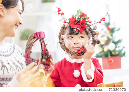Parents and children making a family Christmas wreath 71380070