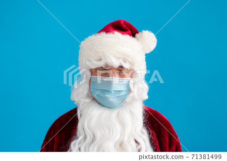 Senior man wearing Santa Claus costume and protective mask 71381499