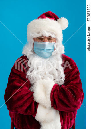 Senior man wearing Santa Claus costume and protective mask Senior man wearing Santa Claus costume and protective mask 71381501
