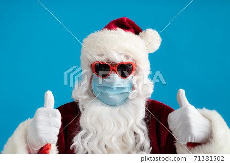 Senior man wearing Santa Claus costume and protective mask Senior man wearing Santa Claus costume and protective mask 71381502
