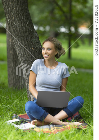 Vertical photo of a smiling student-girl during online lesson. 71382619