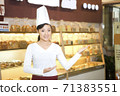 The happy bakery saleswoman is in the bakery  71383551