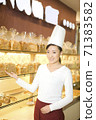 The happy bakery saleswoman is in the bakery  71383582