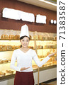 The happy bakery saleswoman is in the bakery 71383587