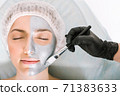 Beauty portrait of a girl lying on a medical table with her eyes closed, while applying a cosmetology mask to her face. The concept of rejuvenation and skin refreshment. 71383633