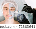 medical procedure. The process of applying a beauty mask to the skin of a patient with her eyes closed lying on a pillow. the concept protection and retardation against ageing and skin care 71383641