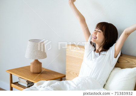躺在床上放鬆的年輕女子 71383932
