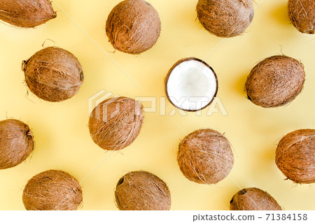 Pattern with coconuts and tropical palm leaves on yellow background. Tropical abstract background. Flat lay, top view. 71384158