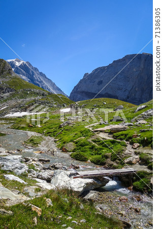 Mountain river and wood bridge in Vanoise national Park valley, French alps 71386305