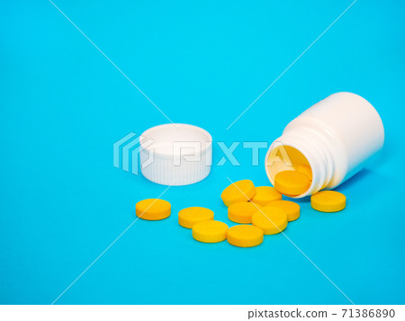 Yellow pills and plastic white bottle Yellow pills and plastic white bottle 71386890