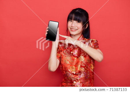 Cute Asian woman wear Chinese dress use a smart mobile phone Cute Asian woman wear Chinese dress use a smart mobile phone 71387133