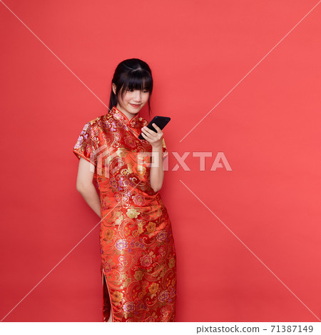 Cute Asian woman wear Chinese dress use a smart mobile phone Cute Asian woman wear Chinese dress use a smart mobile phone 71387149