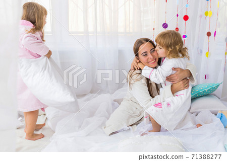 Woman and children on bed. Woman and children on bed. 71388277