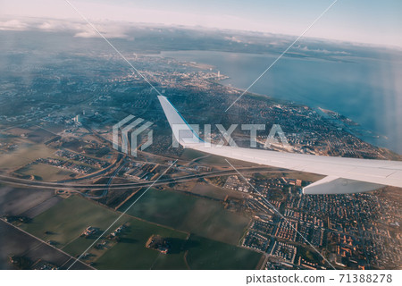 Airplane interior with window view of the Baltic sea and clouds. 71388278