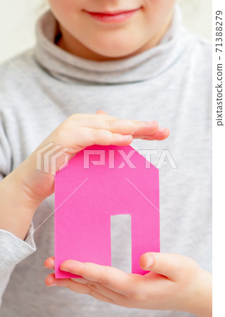 Closeup of paper house in hands of child. 71388279