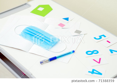 Medical mask with pen over copybook. 71388359