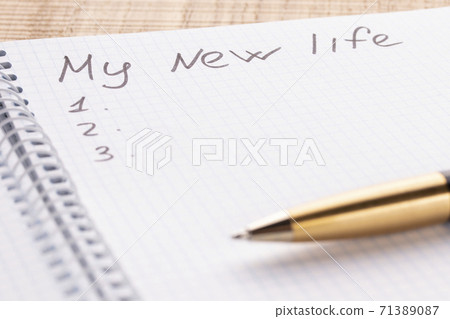Top view workplace notebook and pen on wood table background, retro effect. The inscription is my new life. The concept of updating and changing people Top view workplace notebook and pen on wood table background, retro effect. The inscription is my new life. The concept of updating and changing people 71389087