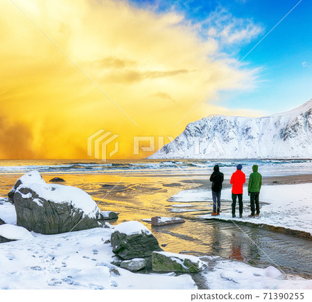 Group of tourist looking  winter scenery on Skagsanden beach with illuminated clouds during sunrise. 71390255