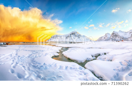 Breathtaking winter scenery on Skagsanden beach with illuminated clouds during sunrise. 71390262