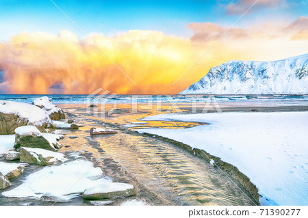Outstanding  winter scenery on Skagsanden beach with illuminated clouds during sunrise. 71390277