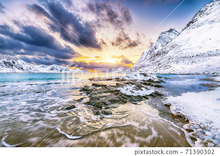 Fabulous winter scenery with Haukland beach during sunset and snowy mountain peaks near Leknes. Fabulous winter scenery with Haukland beach during sunset and snowy mountain peaks near Leknes. 71390302