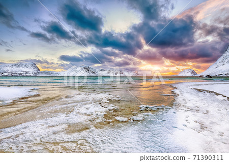 Fabulous winter scenery with Haukland beach during sunset and snowy mountain peaks near Leknes. Fabulous winter scenery with Haukland beach during sunset and snowy mountain peaks near Leknes. 71390311