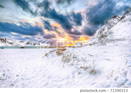Fabulous winter scenery with Haukland beach during sunset and snowy mountain peaks near Leknes. Fabulous winter scenery with Haukland beach during sunset and snowy mountain peaks near Leknes. 71390313