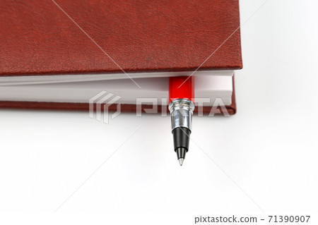 the red pen is inside the notebook. the red pen is inside the notebook. 71390907