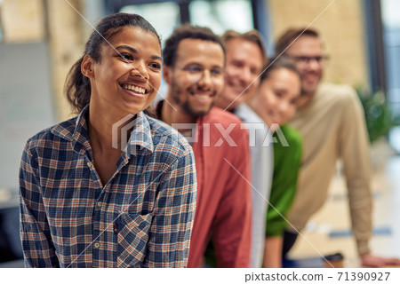 Successful startup team. Group of young happy multiethnic colleagues smiling while posing in the modern office, business people working together Successful startup team. Group of young happy multiethnic colleagues smiling while posing in the modern office, business people working together 71390927