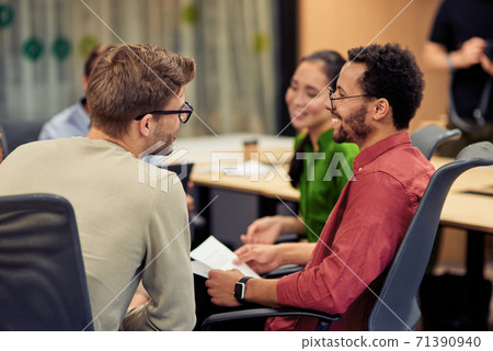 Group of young happy multi racial coworkers communicating and sharing ideas while working together in the modern office Group of young happy multi racial coworkers communicating and sharing ideas while working together in the modern office 71390940