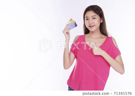 Cheerful young woman wearing casual clothes while holding credit card mockup showing thumb up Cheerful young woman wearing casual clothes while holding credit card mockup showing thumb up 71391576