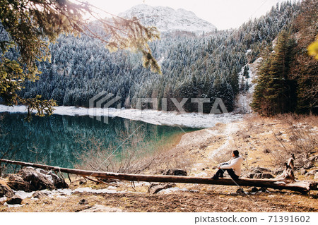woman relax in winter forest with lake view and mountains in snow woman relax in winter forest with lake view and mountains in snow 71391602
