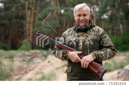 Happy Hunter Old Man in Camouflage with Shotgun. 71391819