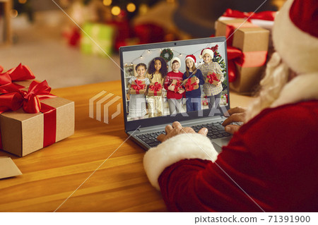 Santa Claus having video call with group of diverse kids using laptop computer in his workshop Santa Claus having video call with group of diverse kids using laptop computer in his workshop 71391900