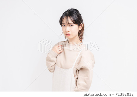 Young woman standing and posing in front of white background Young woman standing and posing in front of white background 71392032