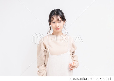 Young woman standing and posing in front of white background Young woman standing and posing in front of white background 71392041