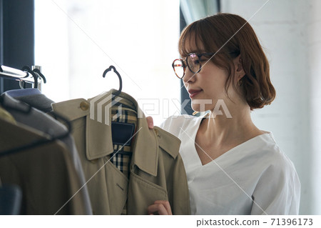 年輕女子撿起外套 71396173