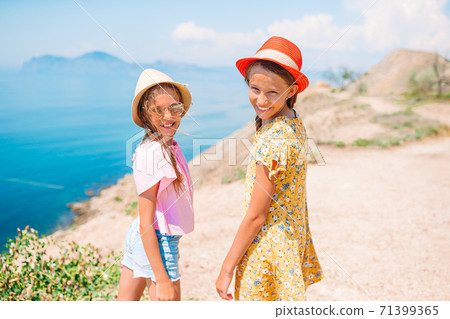 Little happy funny girls have a lot of fun at tropical beach playing together 71399365