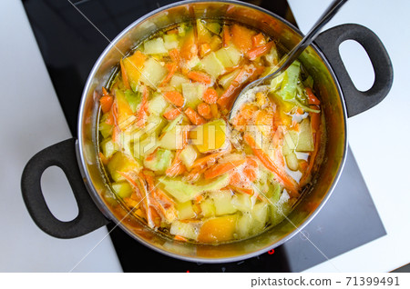 Cooking Bright Vegetable Soup on the Stove 71399491