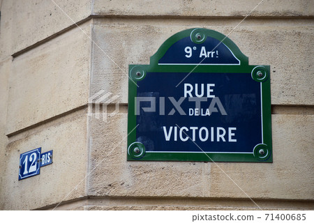Closeup of Victory street name on the traditional parisian street plate on stoned building - (rue de la victoire in french) Closeup of Victory street name on the traditional parisian street plate on stoned building - (rue de la victoire in french) 71400685