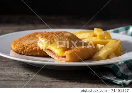 San Jacobo steak filled with cheese and ham on wooden table 71401827